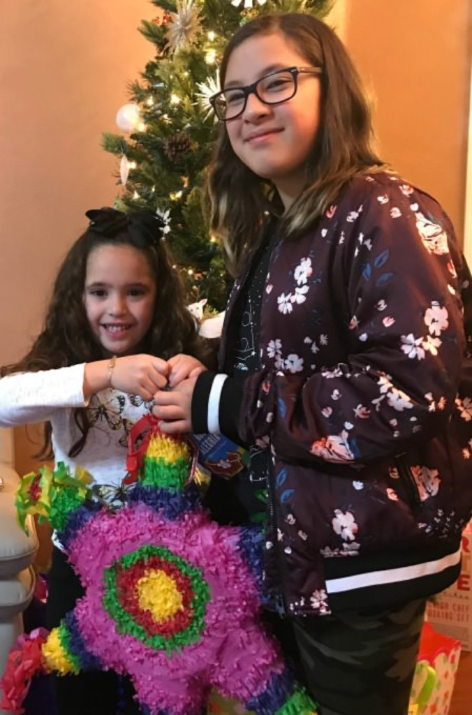 Children in front of Christmas Tree Holding Pinata 