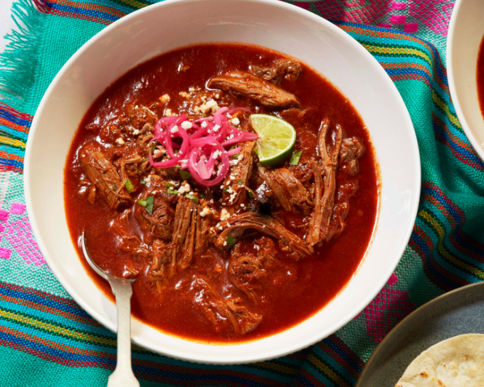 Birria stew recipe plated in white bowl on set table